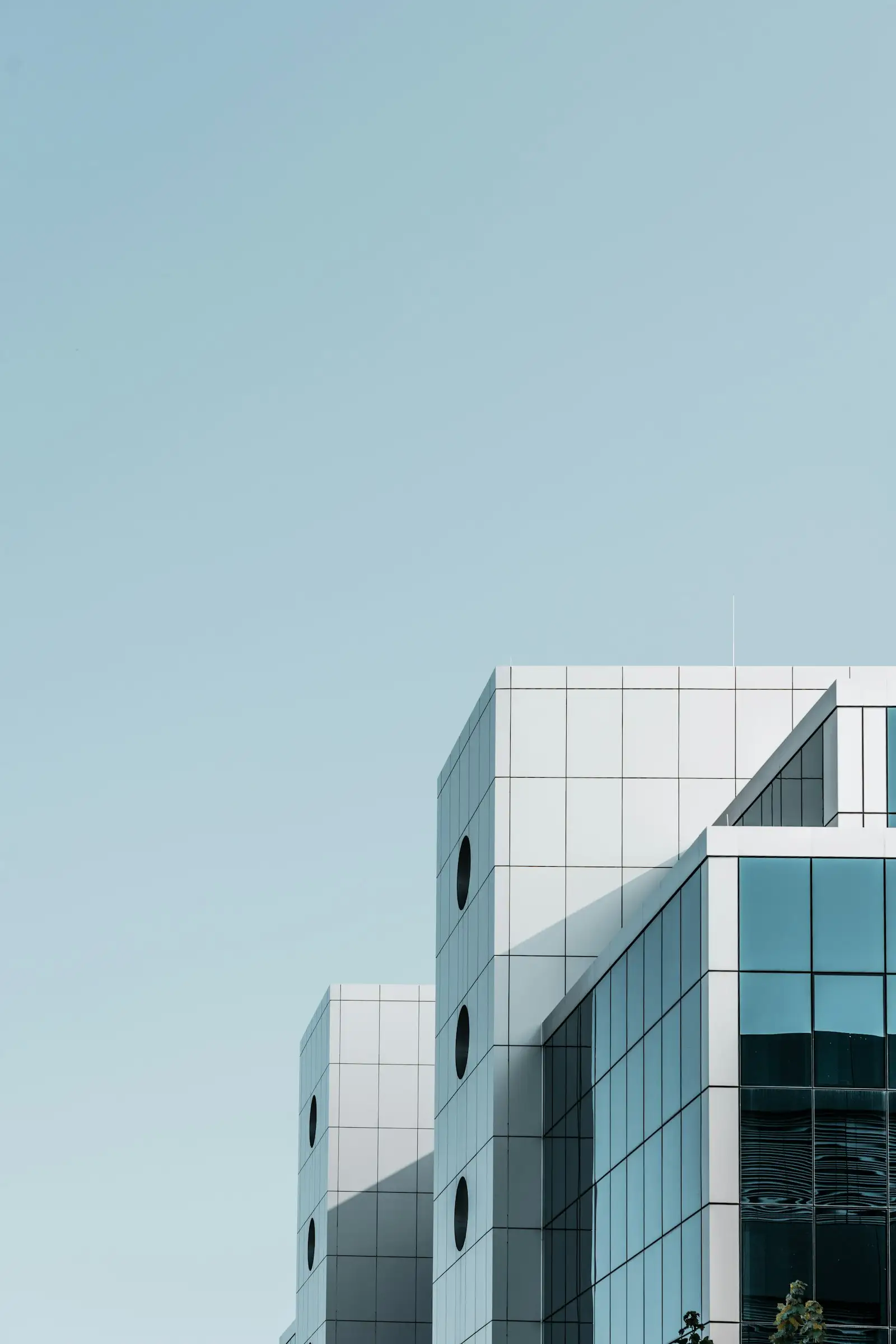 Minimal white commercial building against a pale sky