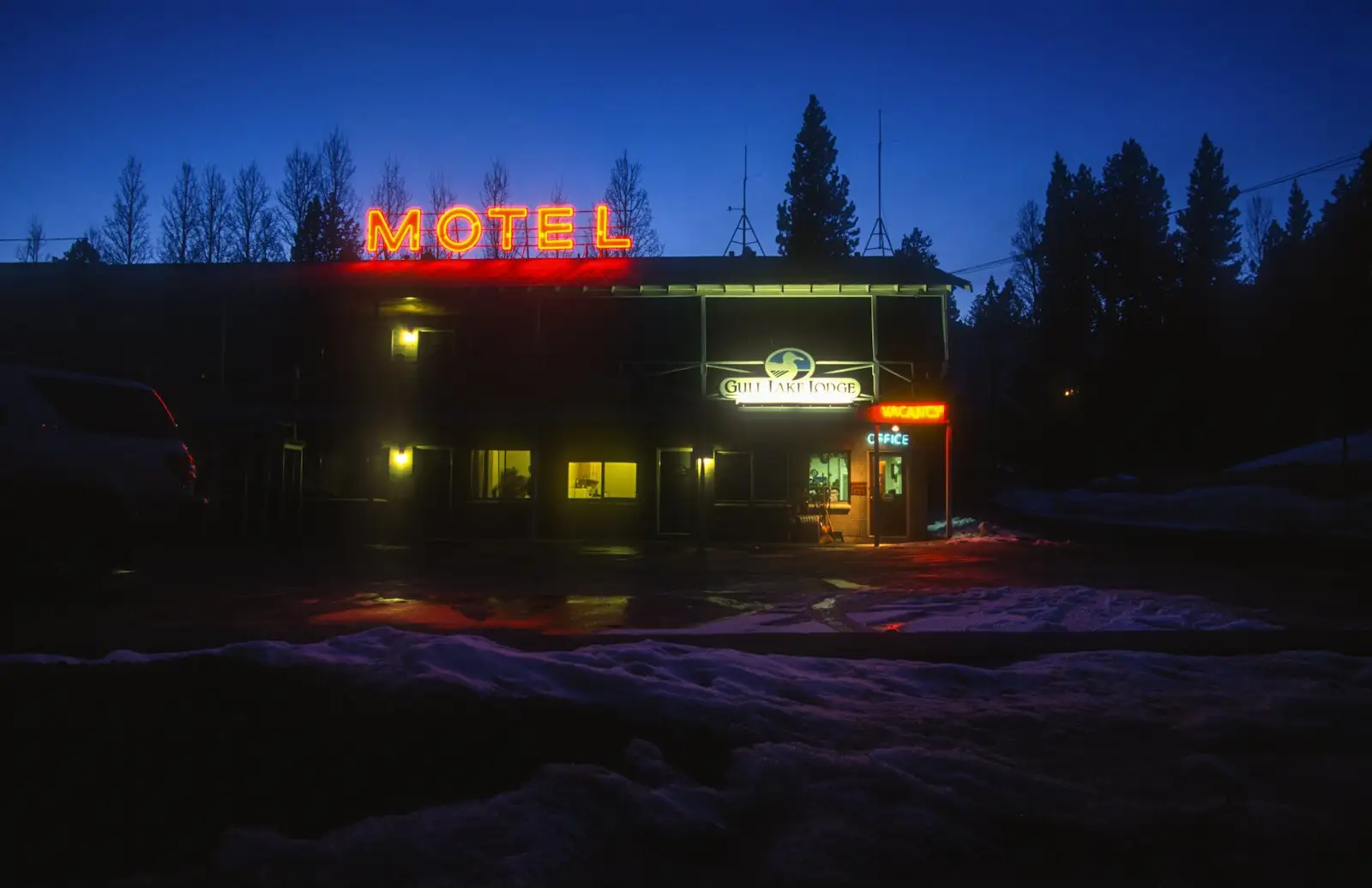 Motel with a lit sign at dusk in winter